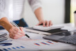 © Daenin - businessman or accountant who are using a calculator to calculate business data Accounting documents and laptop computer at the office business idea