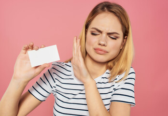 Wall Mural - cheerful woman in a striped T-shirt with a business card in hand Copy space