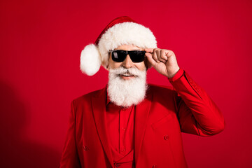 Poster - Photo of self-assured successful nice attractive santa claus wear sunglass x-mas headwear suit on red color background