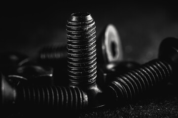 Canvas Print - Grayscale shot of a pile of bolts and nuts on a grunge background