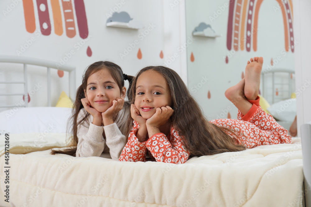 Cute girls in pajamas on bed at home Stock Photo | Adobe Stock