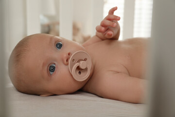 Sticker - Cute little baby with pacifier lying in crib