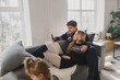 © illustrissima - Happy family at home on the sofa