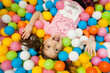 © Евгения Маслова - a girl is lying on a children's playground in colorful balloons