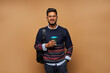 © Тарас Нагирняк - Smiling indian student in glasses with backpack and coffe to go on background