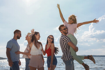 Wall Mural - Group of friends having fun near river at summer party