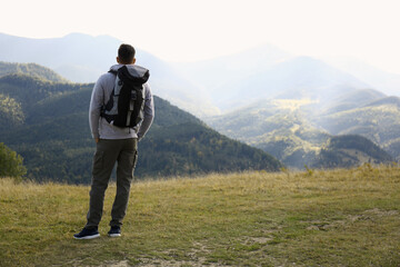 Wall Mural - Man with backpack in mountains, space for text. Tourism equipment