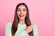 © deagreez - Photo of funky millennial brunette lady point empty space wear green pullover isolated on pink color background