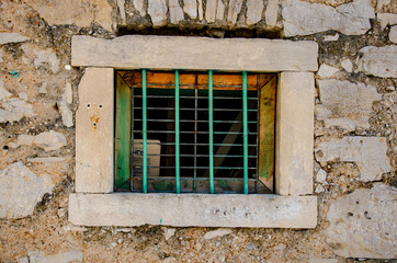 Poster - Beautiful shot of a small window with a metallic cage in an old building