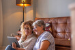 © luciano - Happy loving older mature mother and daughter laughing caring smiling happy senior middle aged mom having fun at home spending time together with technological device