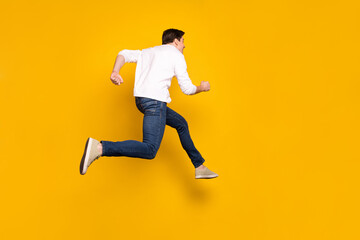 Wall Mural - Full length body size photo man jumping up running fast in casual clothes isolated vivid yellow color background