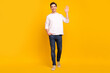 © deagreez - Full body photo of nice brunet millennial guy go wave wear shirt jeans sneakers isolated on yellow color background