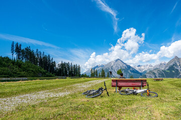 Wall Mural - Biker sitting relaxing on a bench on the mountains during daytime