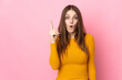 © luismolinero - Young caucasian woman isolated on pink background intending to realizes the solution while lifting a finger up