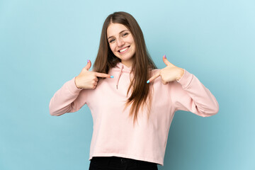 Wall Mural - Young caucasian woman isolated on blue background proud and self-satisfied