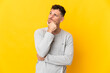 © luismolinero - Young caucasian handsome man isolated on yellow background having doubts