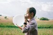 © Cavan Images - smartly dressed boy blowing up a balloon at a wedding in summer