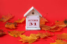 Calendar For October 31 : Decorative House With The Name Of The Month In English, The Number 31, Autumn Maple Leaves On A Red Background, Side View