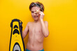 Close-up boy with flippers and starfish with yellow background. Traveling on vacation at sea with children. Summer vacation at school basis for banner