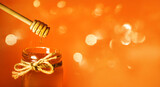 Fototapeta  - miód w słoiku i łyżka do miodu z lejącym się miodem na pomarańczowym tle, Kropla miodu