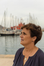 Caucasian Adult Female Caucasian Looking To The Side Near A Harbor With Moored Boats