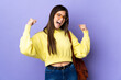 Teenager Brazilian student girl over isolated purple background celebrating a victory