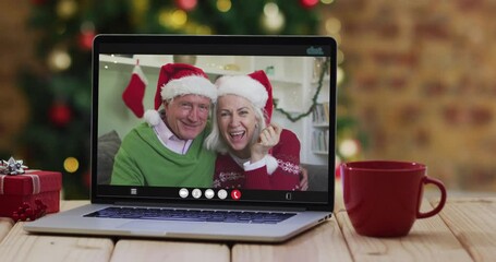 Sticker - Caucasian senior couple waving on video call on laptop, with christmas tree