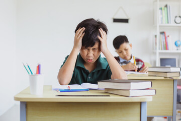 Elementary school boy tired and stressed doing exams in class