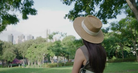 Wall Mural - Woman with straw hat at the green park