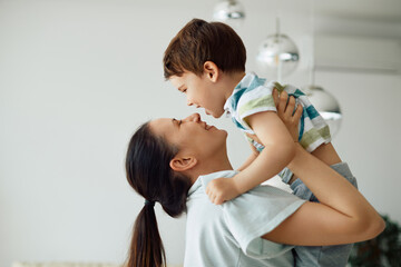 Wall Mural - Carefree mother and son have fun together at home.