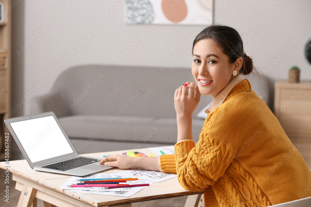 Young female calligraphist working in office