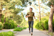 © Pixel-Shot - Sporty young man with headphones running in park