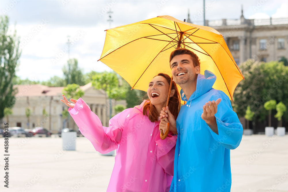 Young couple with umbrella walking outdoors