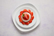 Plate with delicious strawberry panna cotta on light background