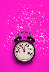 Wall Mural - New Year's Eve background concept. 2021 changes to 2022 on an alarm clock on a pink background with festive glitter on New Year's Eve and Christmas.