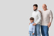© Pixel-Shot - Happy man, his little son and father on light background