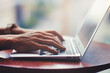 © beeboys - 窓際でラップトップを使用する人物の手元クローズアップ 背景ぼかし