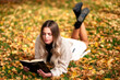 © Jaroslav Moravcik - Girl lying on ground in colorful autumn park and reading a book