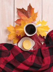 Wall Mural - cup of coffee and autumn maple leaves on an old wooden table