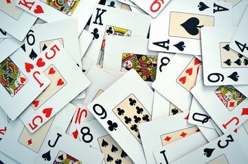 Poker Game Cards - Photo of cards mixed on a table showing all suits - Hearts, Spades, Diamonds and Clubs