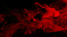 Drops Of Red Ink In Water. Cosmic Star Background. Red Watercolor Paints In Water On A Black Background. Beautiful Wallpaper For Your Desktop. Red Cloud Of Ink.