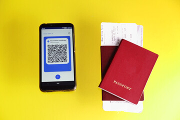 vaccination certificate on the smartphone display,  passport and airplane ticket