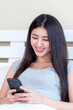 © suphaporn - Beautiful cute girl Asian woman playing a smart phone shopping online in white bedroom - lifestyle female online shopping at home concept