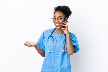 Sticker - Young surgeon African American doctor woman isolated on white background keeping a conversation with the mobile phone with someone