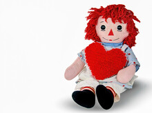 Old Rag Doll With Red Yarn Heart Isolated On White 