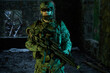© amixstudio - Portrait of airsoft player in professional equipment with machine gun in abandoned ruined building. Soldier with weapons at war