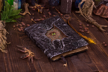 Close the book of black magic with the image of the eye of the sea monster. Mystical still life with scary occult objects, horrible halloween and black magic concept
