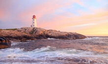 Peggy’s Cove Lighthouse Illuminated At Sunset With Dramatic Purple Sky And Waves, Nova Scotia, Canada