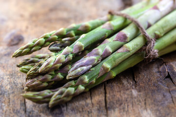 Wall Mural - Green fresh asparagus on old wooden background.