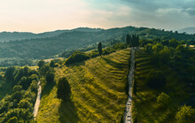 Aerial View Of A Beautiful Landscape With An Idyllic Stepped Hill In The Foreground Illuminated By Late Afternoon Light In The Po Valley, Italy.